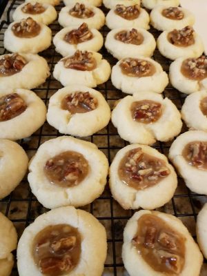 Thumbprint cookies with pecan pie filling, pecan filled cookies on a cooling rack