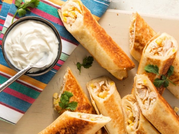 Chicken taquitos recipe, easy baked in the oven or fried in oil, plated and served with sour cream and salsa.