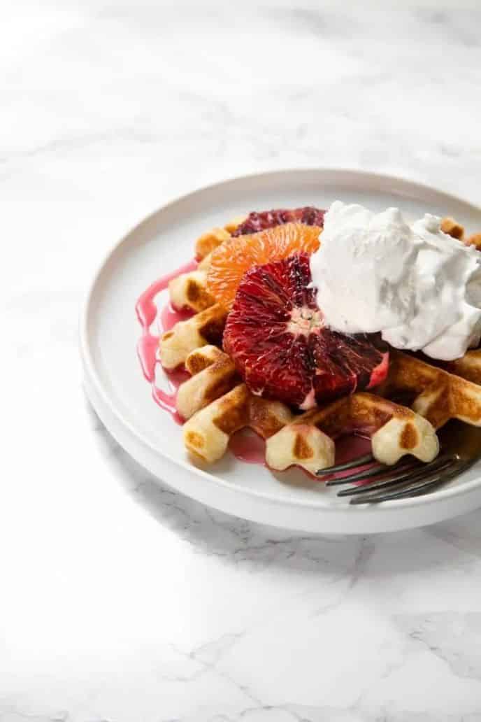 11 Savory and Sweet Waffle Toppings, Blood orange glaze on top of waffles with whipped cream