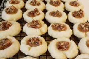 Thumbprint cookies recipe filled with pecan pie filling, all homemade, cookies in rows on cookie rack