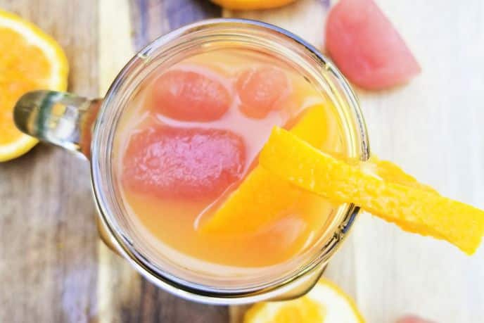 Brunch cocktail with cranberry juice and orange juice with juice ice cubes in a glass