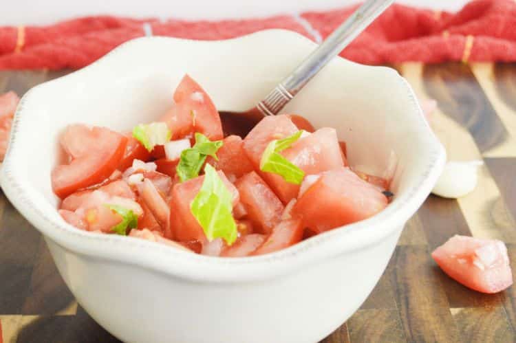 Tomato salad recipe with basil and onion, perfect side dish served in a white flower patterned bowl